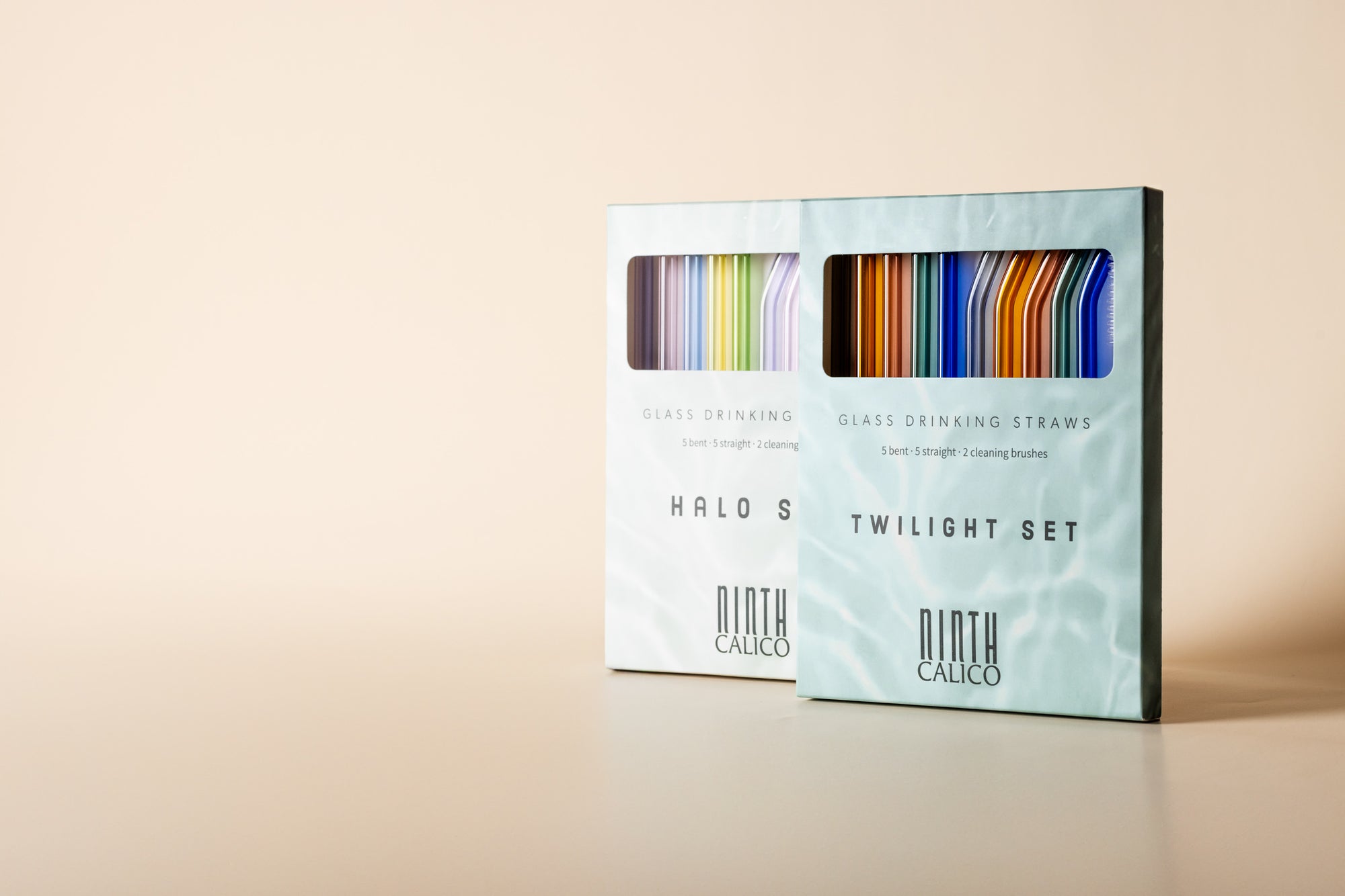 Halo and Twilight classic glass straw sets side by side standing in the case